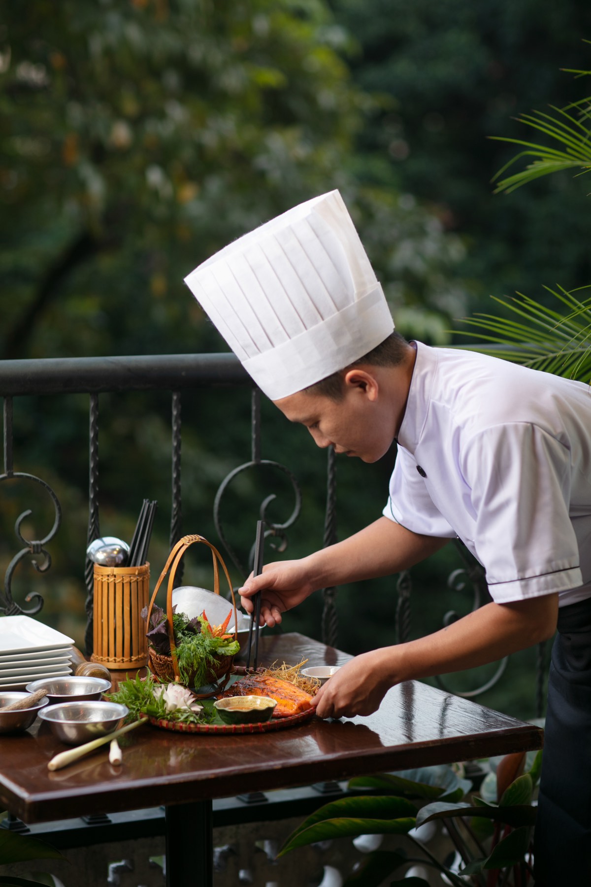 Chef plating a dish on the balcony